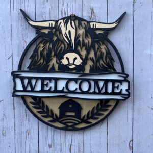 Welcome sign with a highland coo
