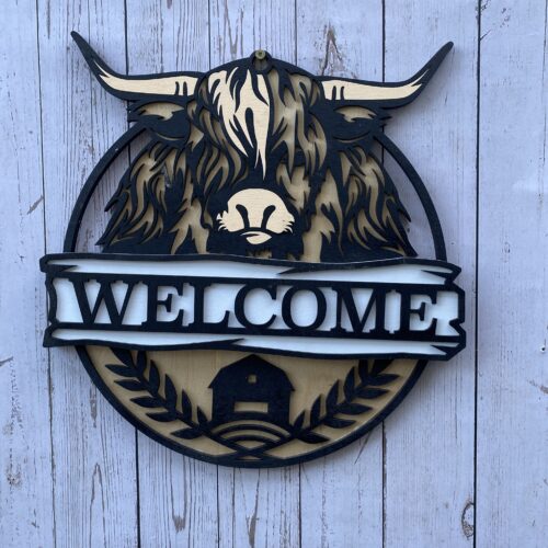 Welcome sign with a highland coo