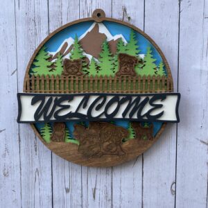 Welcome sign with mountains and trees