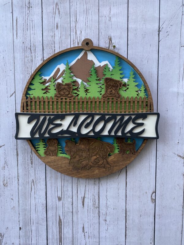 Welcome sign with mountains and trees